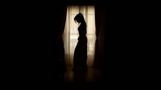 暗い部屋でうつむく女性